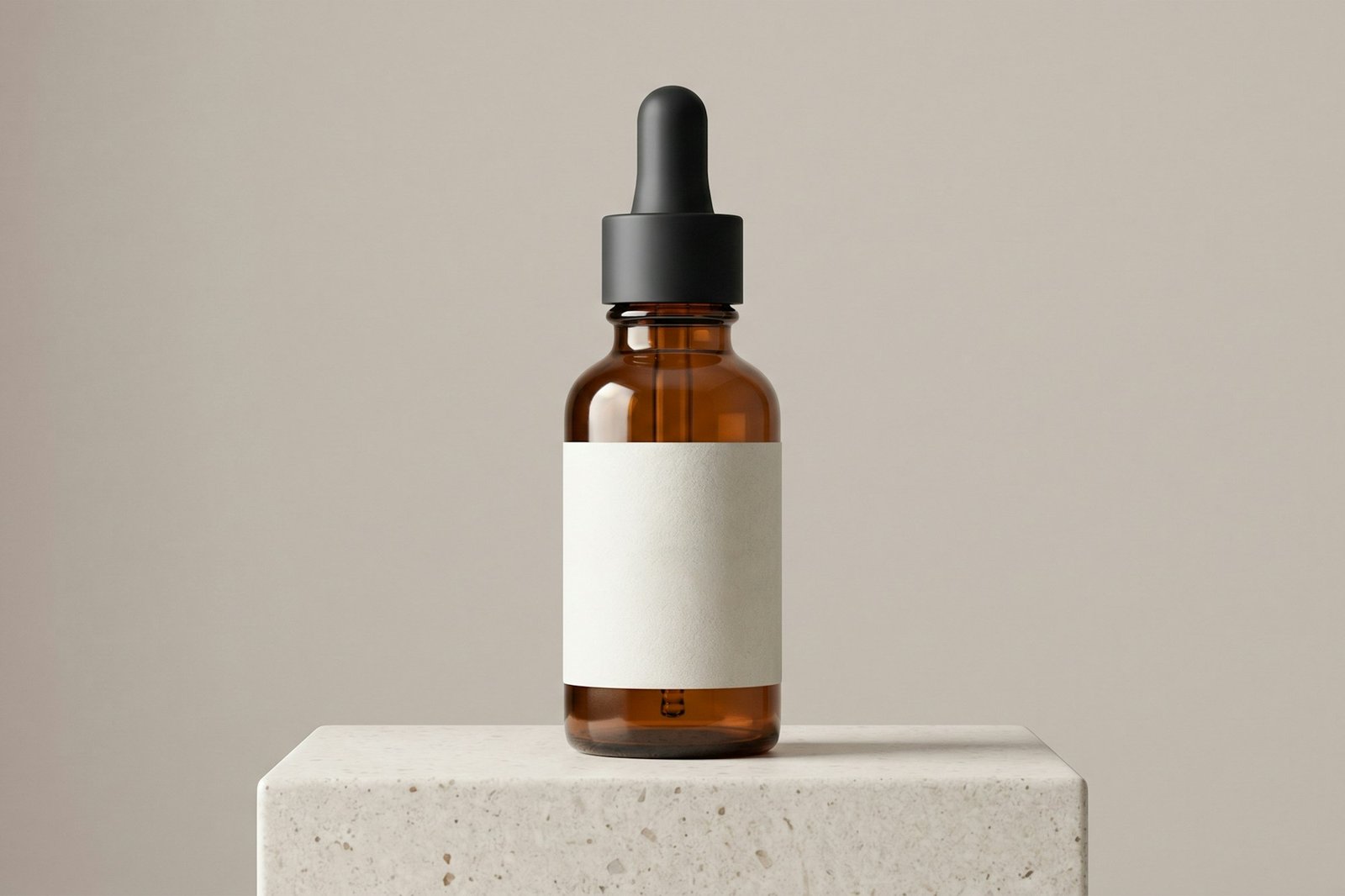 An amber skincare dropper bottle with a blank label on a concrete block