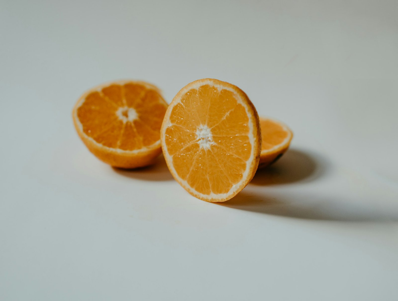 Sliced oranges, a natural source of vitamin C, on a light background